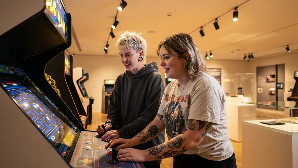 Computerspielemuseum Berlin – Zwei Personen spielen an einem Retro-Arcade-Automaten