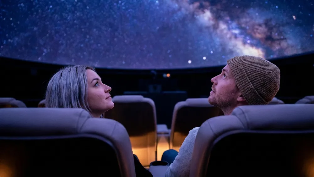 Zeiss-Großplanetarium Berlin – Zwei Personen schauen auf den projizierten Sternenhimmel unter der Kuppel