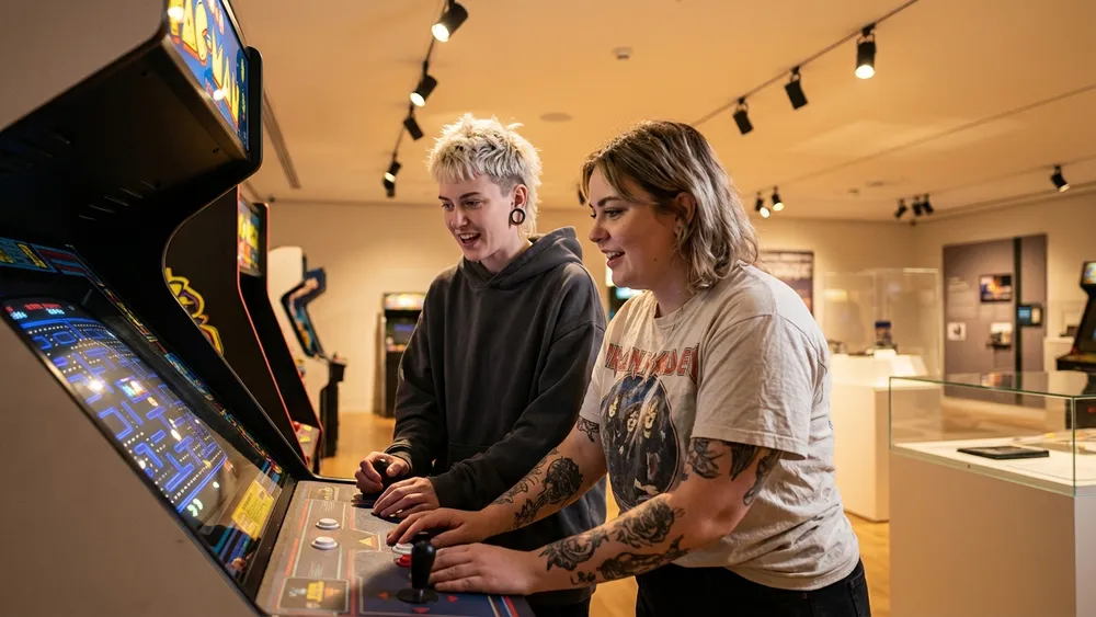Computerspielemuseum Berlin – Zwei Personen spielen an einem Retro-Arcade-Automaten