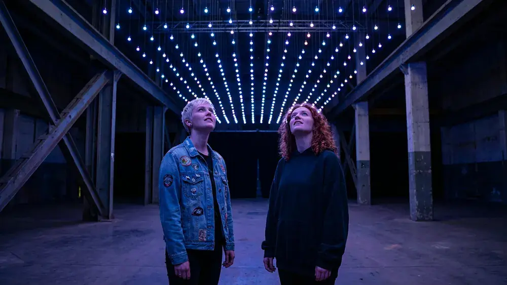 Dark Matter Berlin – Zwei Personen stehen staunend unter einer kinetischen Lichtinstallation