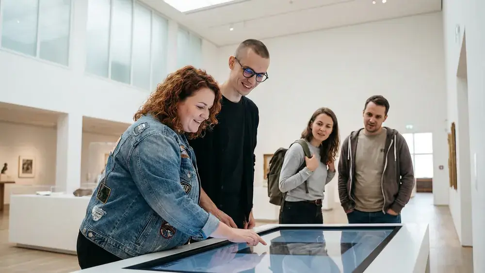 Futurium in Berlin – Gruppe an einer interaktiven Ausstellung im Zukunftsmuseum