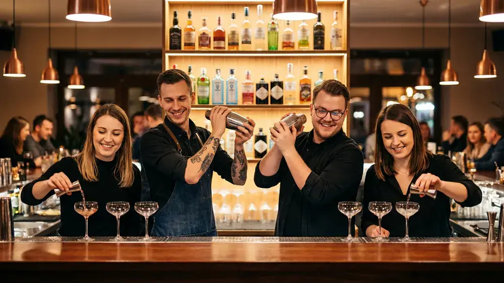 Cocktailkurs in Berlin – Team mixt Cocktails an einer Bar unter Anleitung in Kreuzberg
