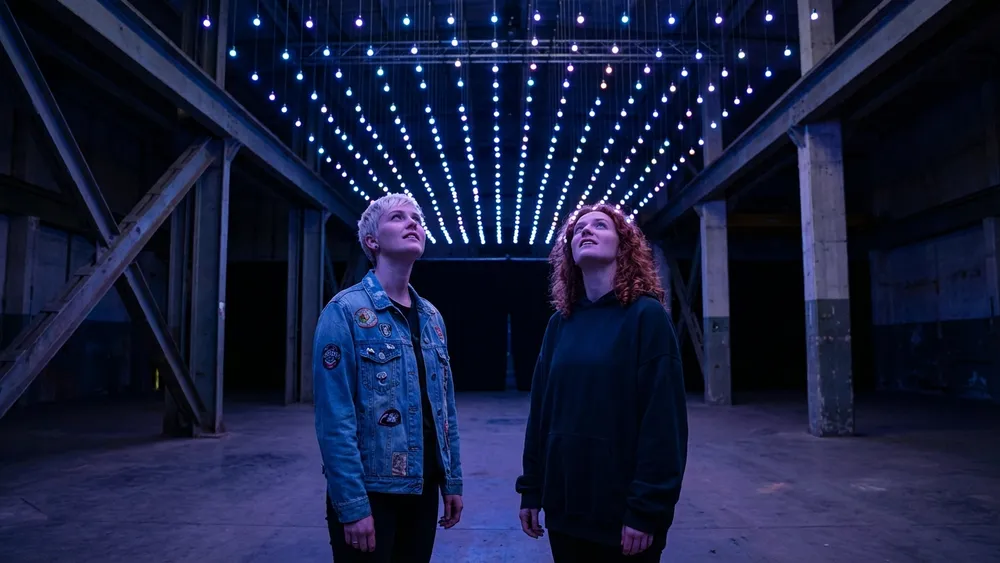 Dark Matter Berlin – Team steht staunend unter einer kinetischen Lichtinstallation in Oberschöneweide