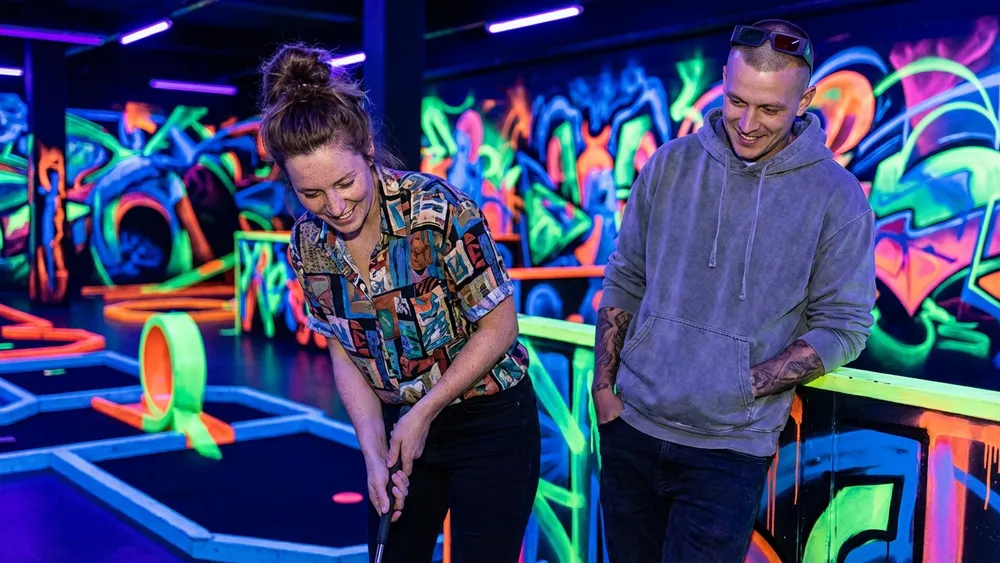 Schwarzlicht-Minigolf in Berlin – Team spielt mit 3D-Brillen Minigolf in leuchtender Neonwelt im DockX Tempelhof