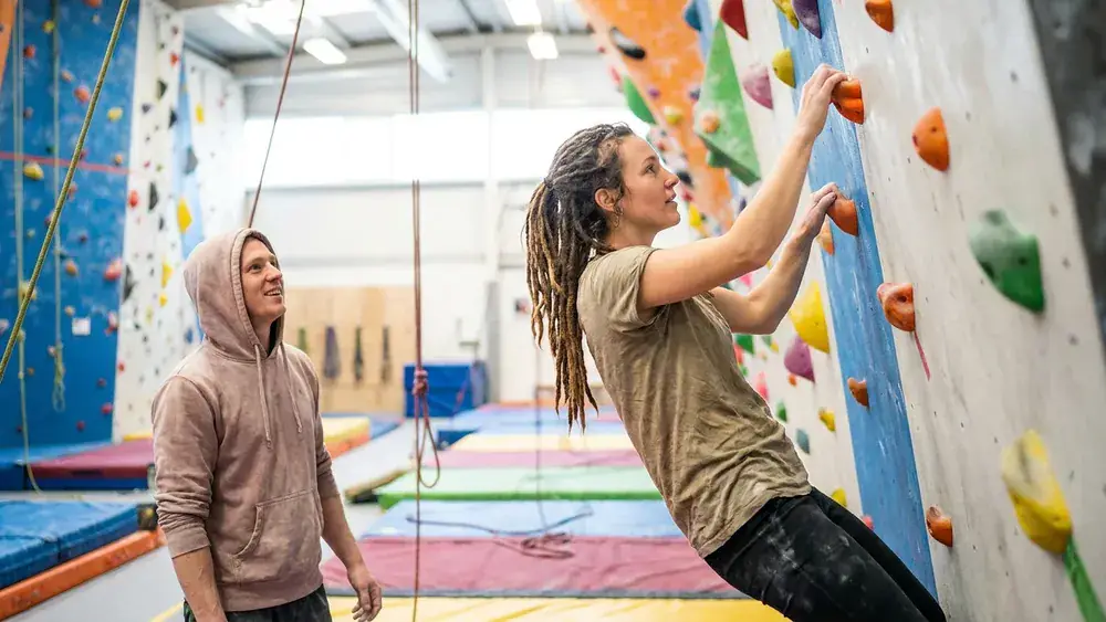 Bouldern Südbloc Berlin – Zwei Personen klettern an bunten Griffen in der Halle