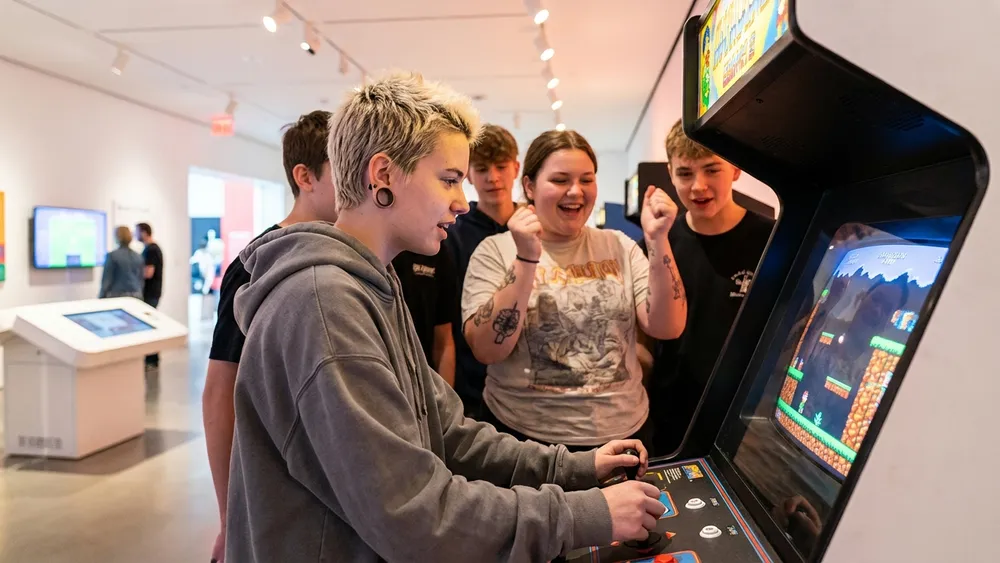 Computerspielemuseum Berlin – Schulklasse spielt an einem Retro-Arcade-Automaten