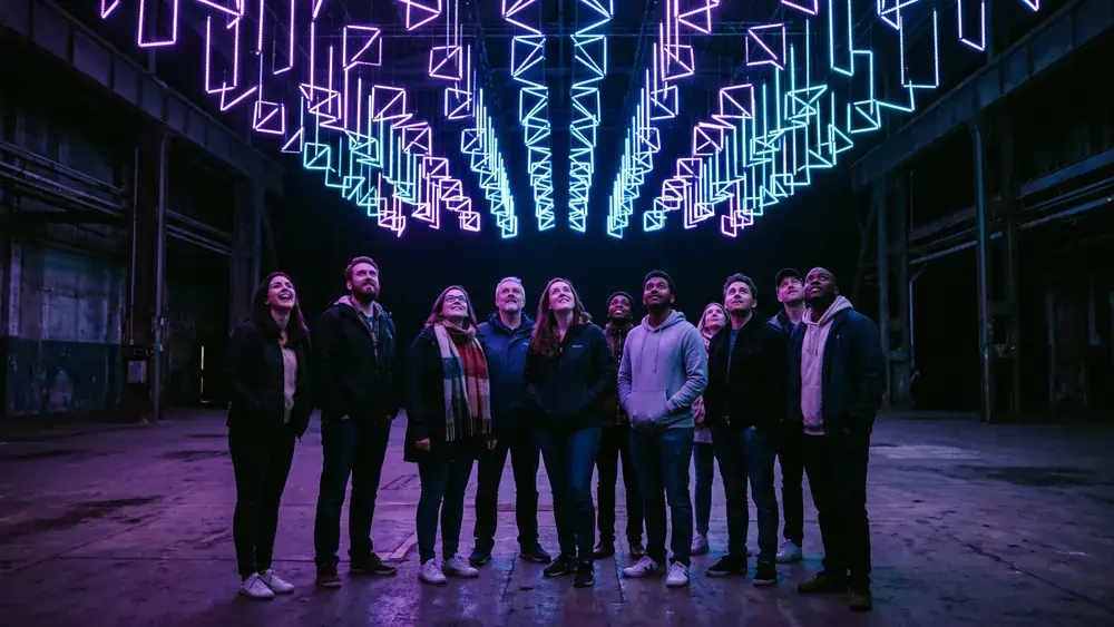 Dark Matter Berlin – Kollegen stehen staunend unter einer kinetischen Lichtinstallation in Oberschöneweide