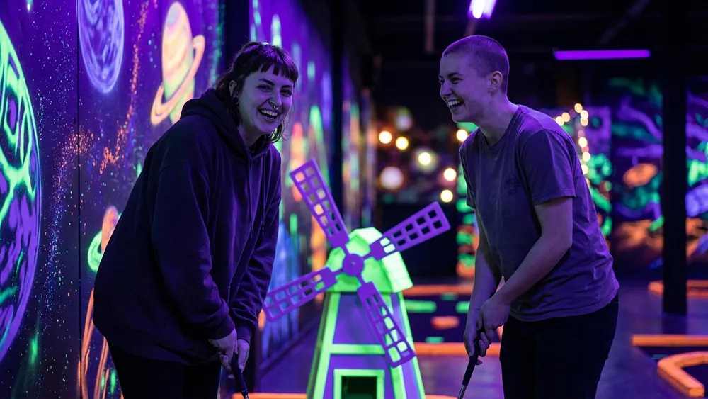 GolfZone Schwarzlicht Minigolf in Bielefeld – Zwei Personen spielen im Neonlicht