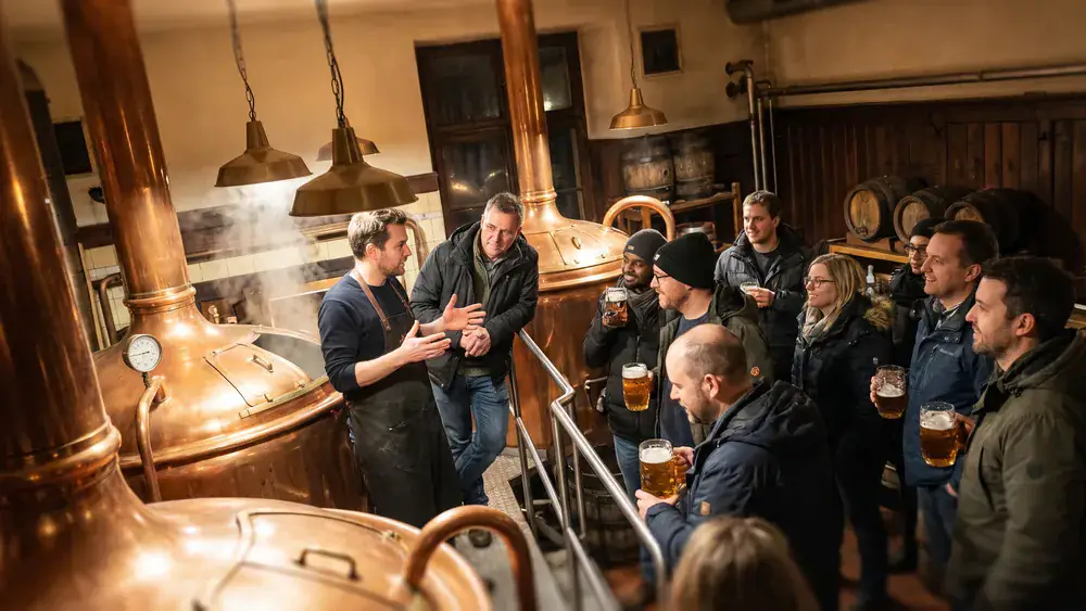 Brauereiführung in Bielefeld – Kollegen an Kupferkesseln mit Brauer im Joh. Albrecht Brauhaus