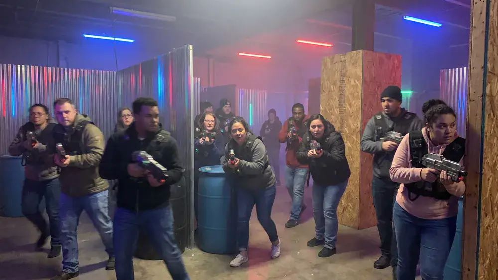 Lasertag in Bielefeld – Kollegen in taktischen Westen spielen in einer dunklen Neon-Arena in Stieghorst