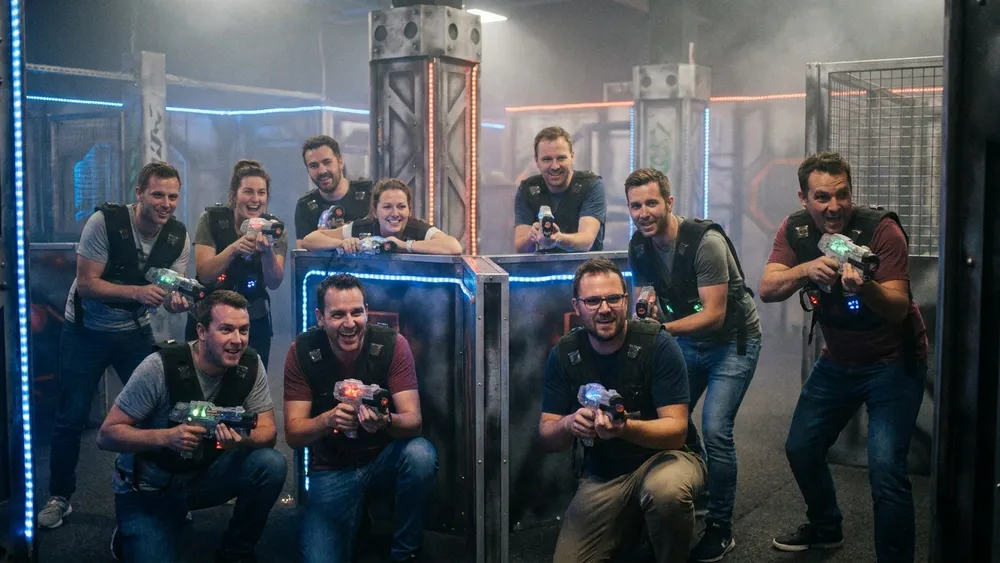 Lasertag in Bielefeld – Gruppe in taktischen Westen spielt in einer dunklen Neon-Arena in Stieghorst