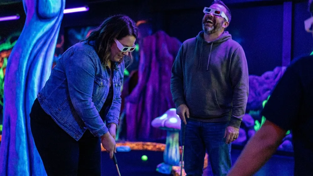 Schwarzlicht Minigolf in Bielefeld – Gruppe spielt mit 3D-Brillen Minigolf in leuchtender Neonwelt