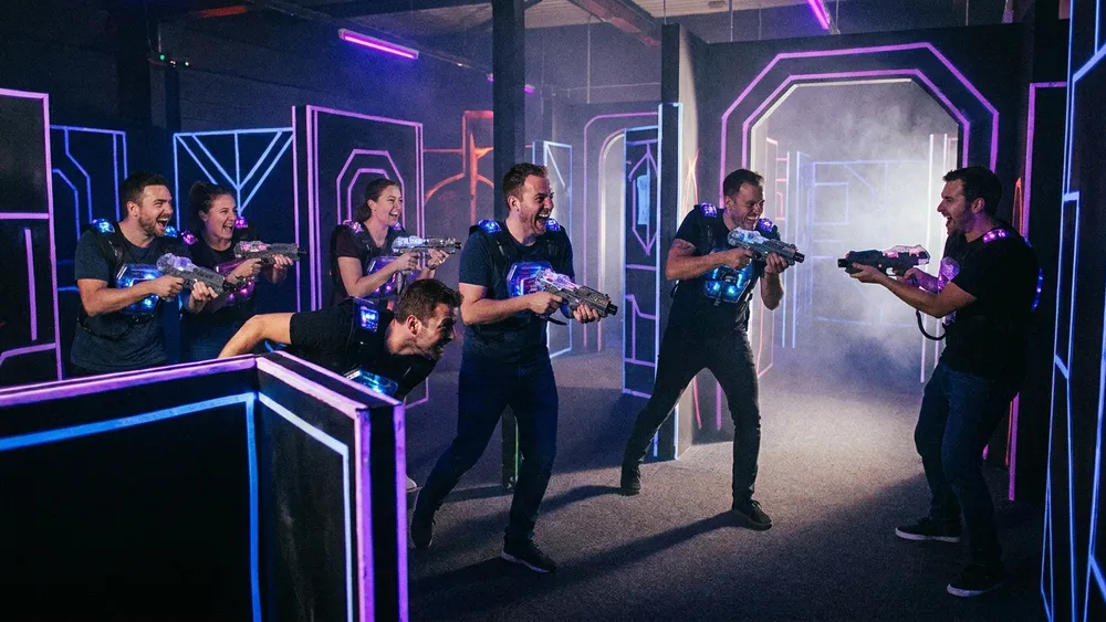 LaserZone Bielefeld - Erwachsene spielen Lasertag in einer dunklen Neon-Arena