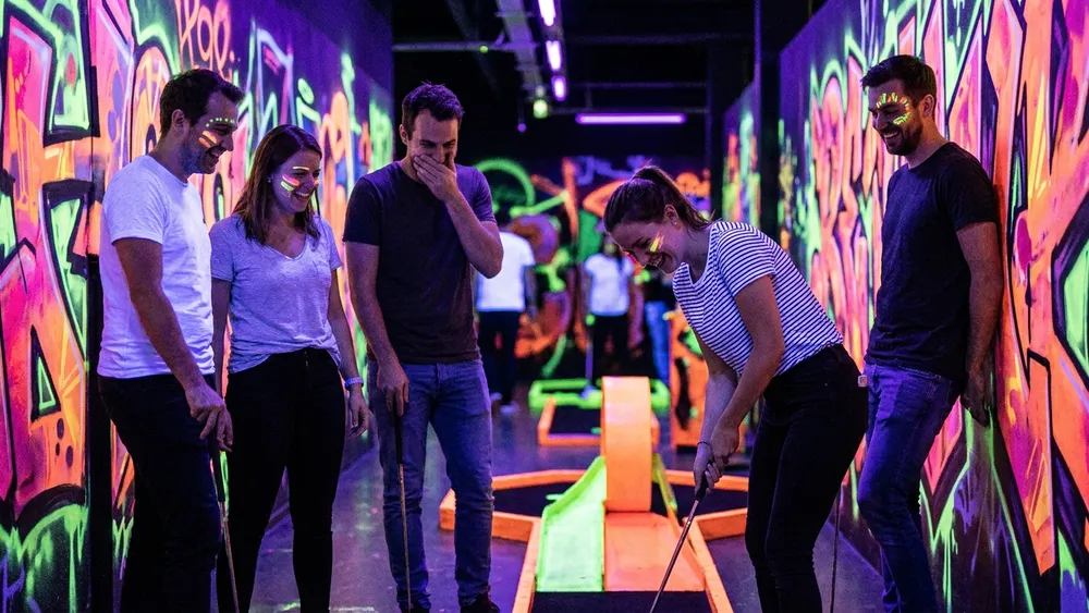 GlowZone Schwarzlicht Minigolf in Bielefeld - Erwachsene spielen Minigolf im Neonlicht