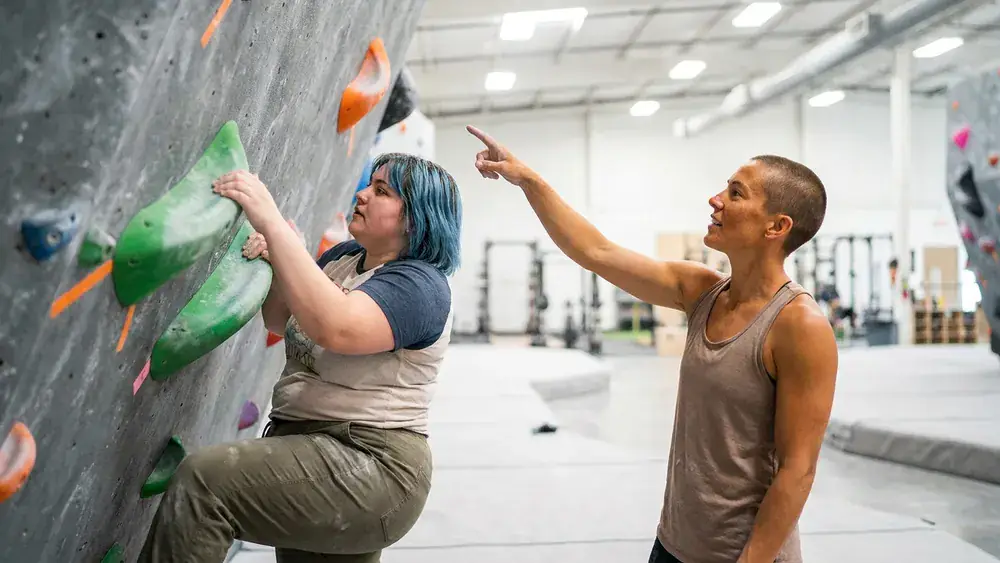 Bouldern in Bielefeld – Zwei Personen klettern am Sonntag an bunten Griffen