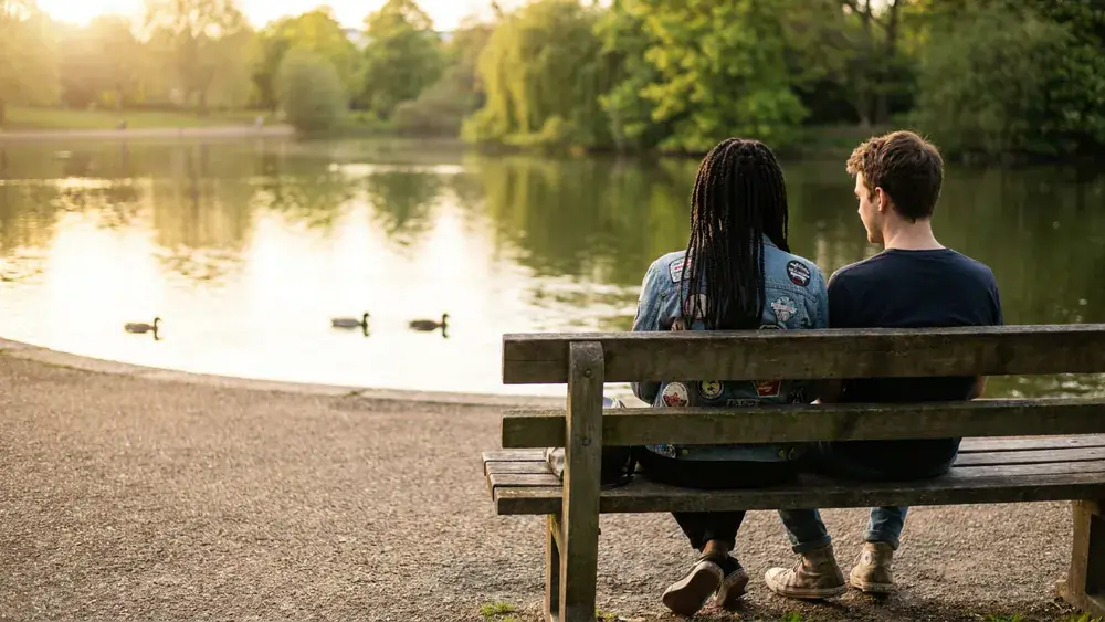 Obersee in Bielefeld – Zwei Personen sitzen am Sonntag auf einer Bank am See