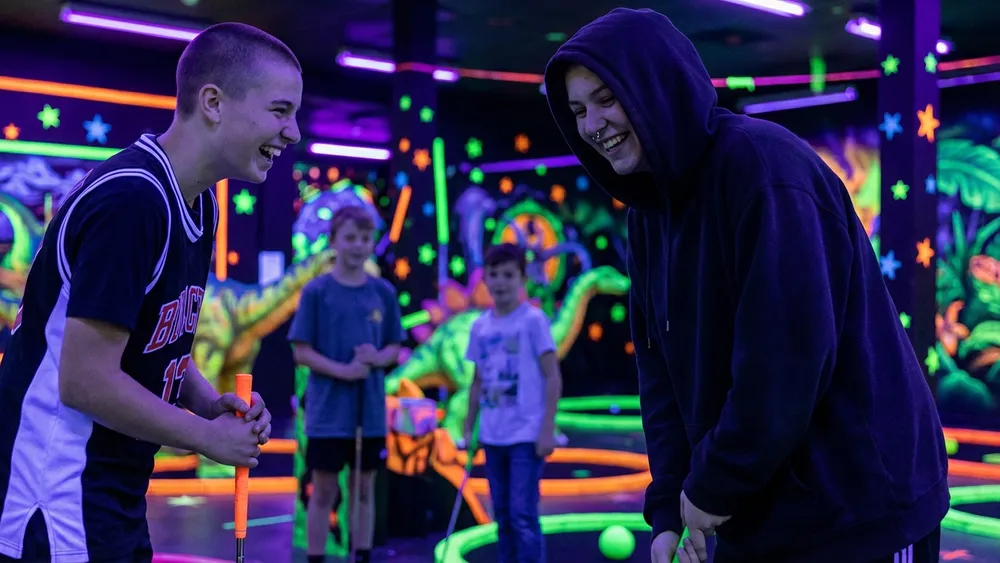 GolfZone Schwarzlicht Minigolf in Bielefeld – Schüler spielen Minigolf im Neonlicht