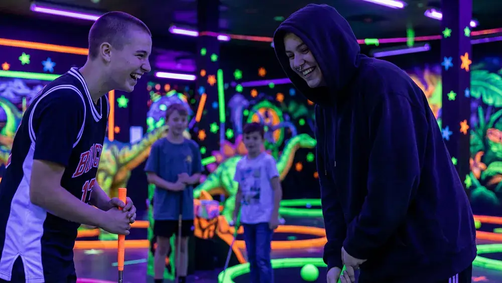 GolfZone Schwarzlicht Minigolf in Bielefeld – Schüler spielen Minigolf im Neonlicht