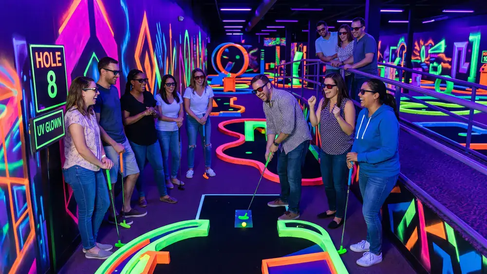 Schwarzlicht Minigolf in Bielefeld – Kollegen spielen zur Weihnachtsfeier mit 3D-Brillen Minigolf in leuchtender Neonwelt
