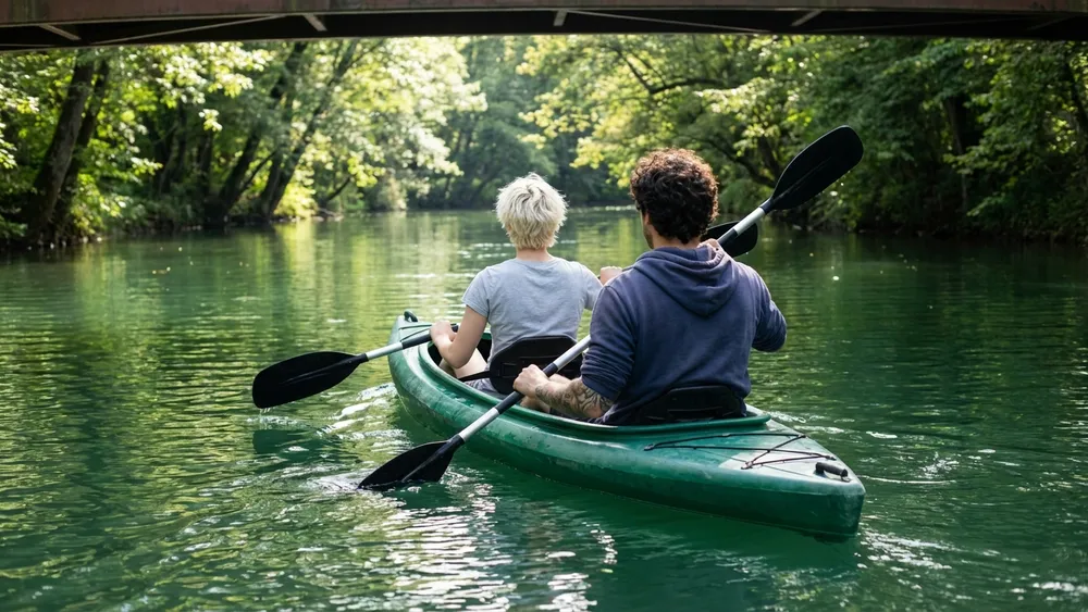 Bootsverleih auf der Oker in Braunschweig – zwei Personen paddeln im Kajak durch grüne Ufer