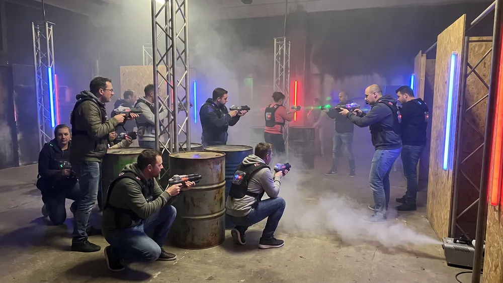 Lasertag in Braunschweig – Kollegen mit Sensorwesten spielen in einer dunklen Neon-Arena