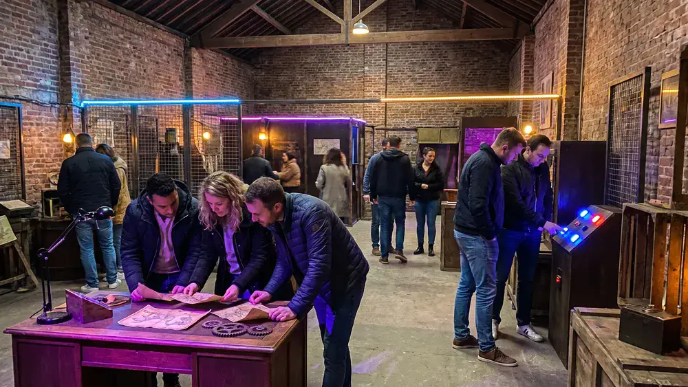 Mind Arena in Braunschweig – Kollegen lösen Rätsel an mehreren beleuchteten Stationen in einer großen Escape-Game-Halle