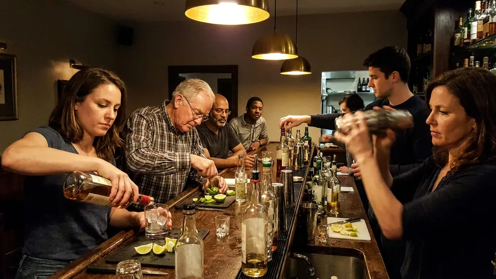 Cocktailkurs in Braunschweig – Gruppe mixt Cocktails hinter einer Bar