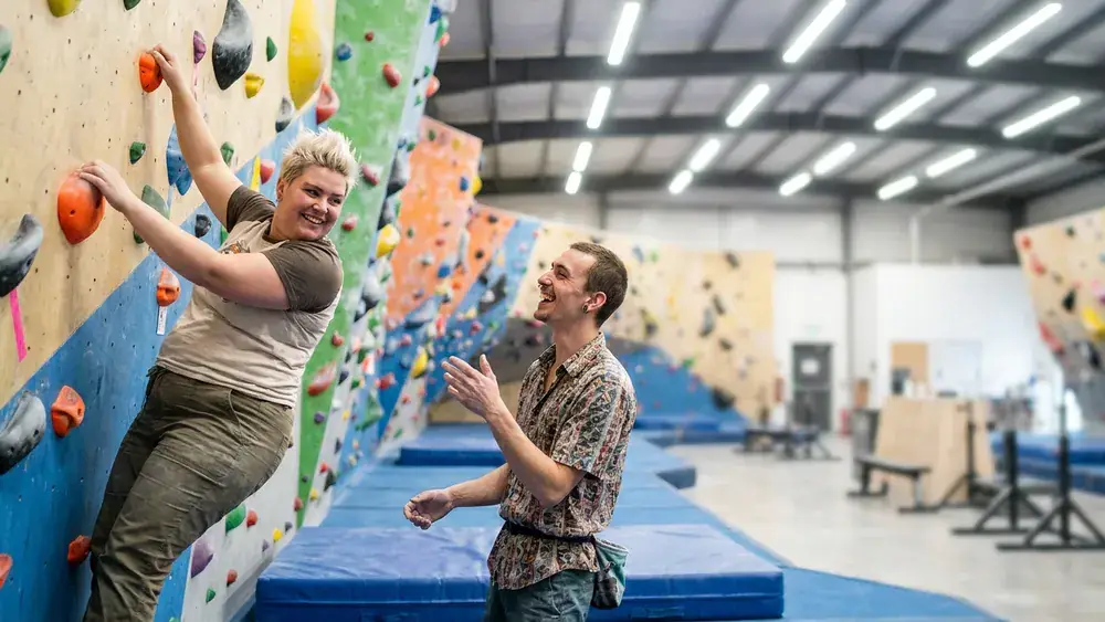 Greifhaus Boulderhalle in Braunschweig – zwei Personen klettern an bunten Griffen