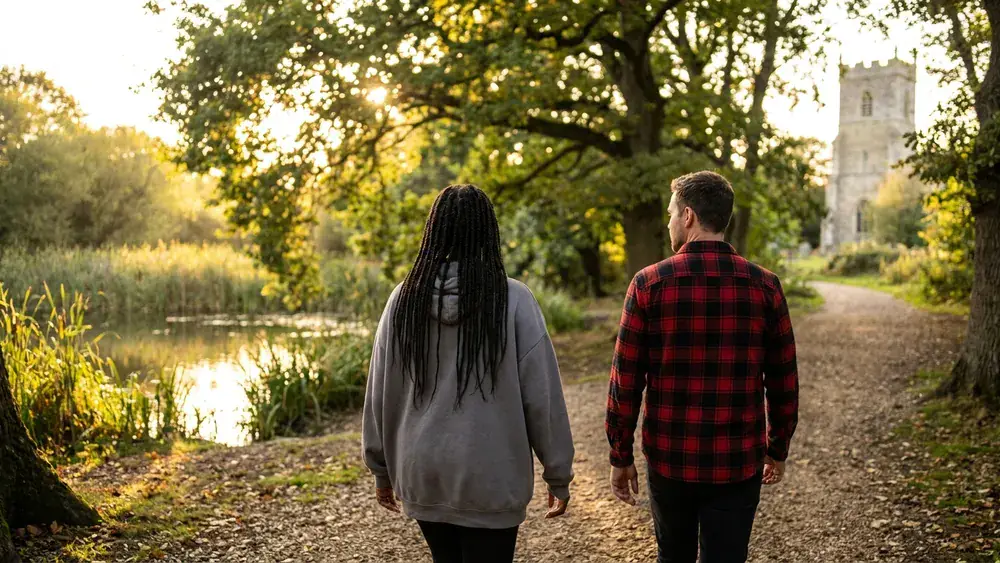 Riddagshausen in Braunschweig – zwei Personen spazieren durch das Naturschutzgebiet mit Klosterkirche im Hintergrund