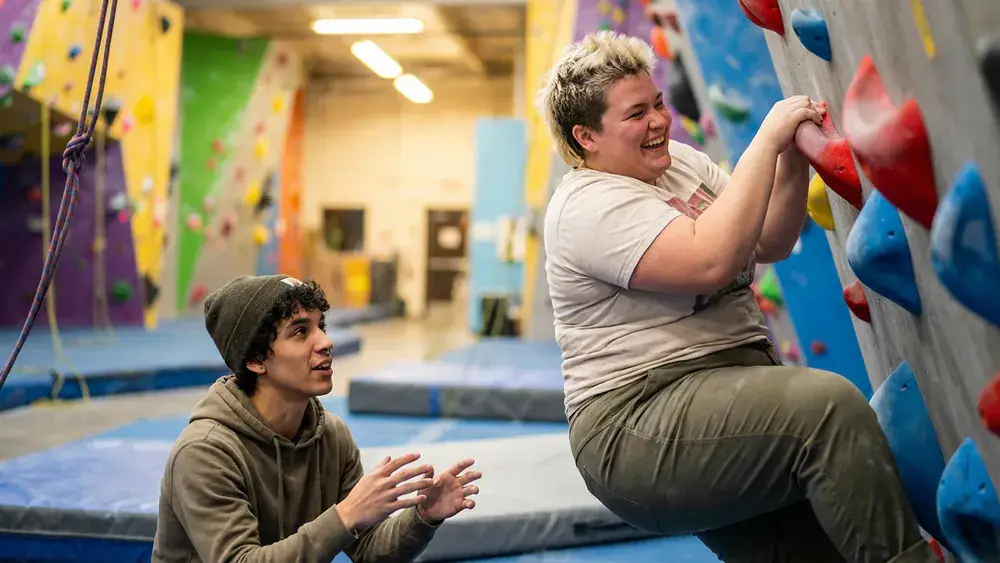 Greifhaus Bouldern in Braunschweig – Team klettert gemeinsam an bunten Boulderwänden in einer hellen Halle