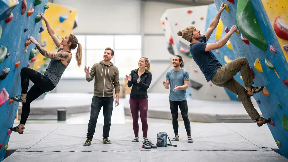Greifhaus Bouldern in Braunschweig – Kollegen klettern gemeinsam an bunten Boulderwänden in einer hellen Halle