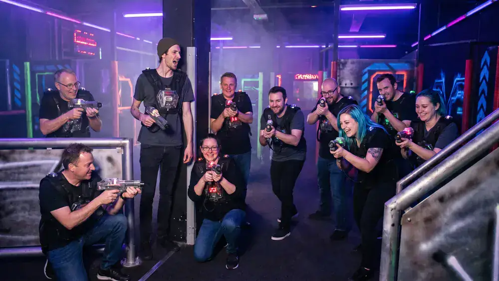 Lasertag in Braunschweig – Kollegen in tactical vests spielen in einer dunklen Arena mit Neonlicht