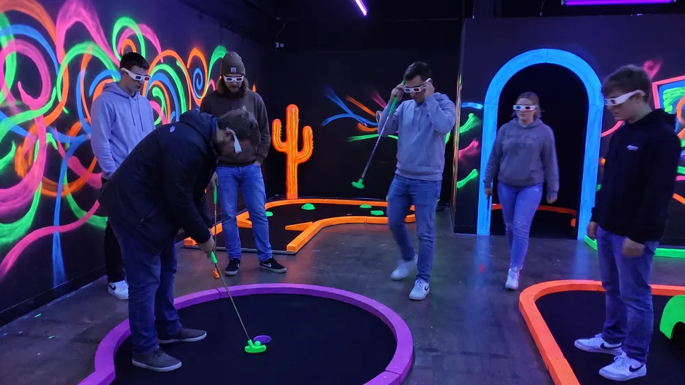 Glowing Rooms in Dortmund – Kollegen spielen Schwarzlicht-Minigolf mit 3D-Brillen in leuchtender Neonwelt