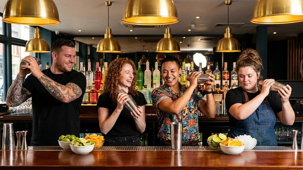 Cocktailkurs in Dortmund – Gruppe mixt Cocktails an einer Bar unter Anleitung