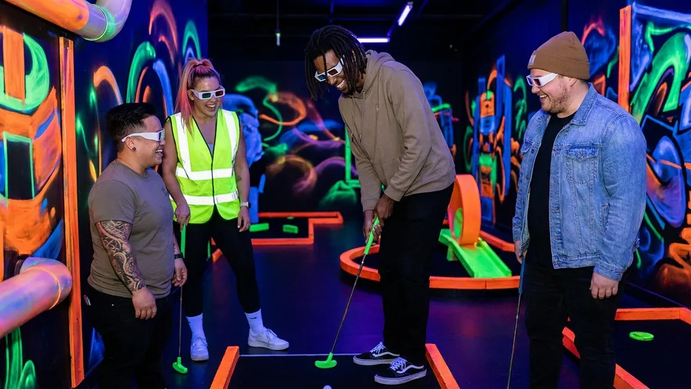 Glowing Rooms in Dortmund – Gruppe spielt Schwarzlicht-Minigolf mit 3D-Brillen