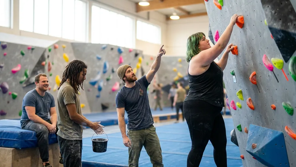 Kletterhalle Bergwerk in Dortmund - Erwachsene bouldern gemeinsam an einer bunten Kletterwand