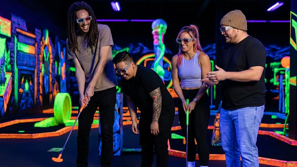 Glowing Rooms in Dortmund - Erwachsene spielen Schwarzlicht-Minigolf mit 3D-Brillen