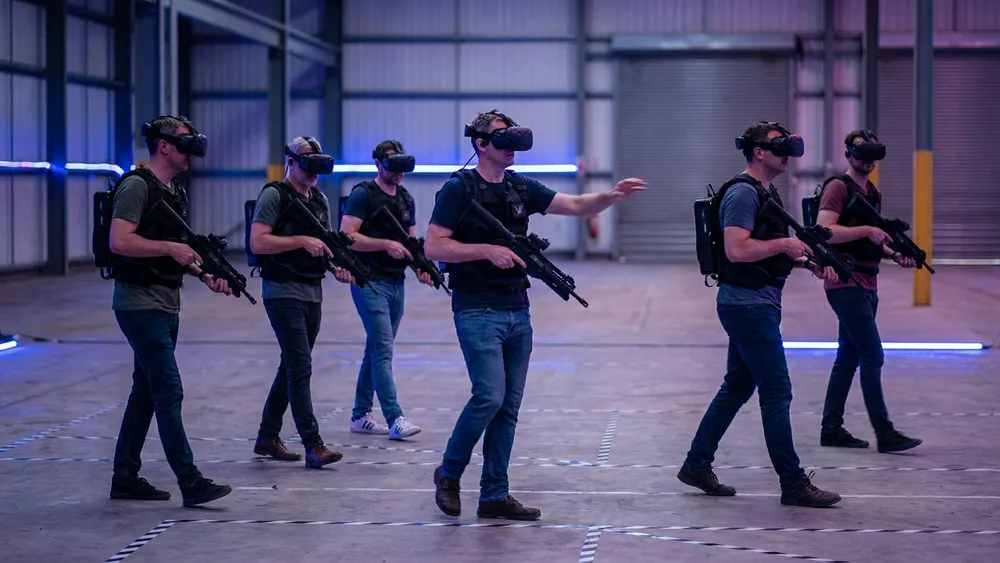 Zero Latency VR in Dortmund - Erwachsene mit VR-Brillen und Westen laufen frei durch eine virtuelle Welt