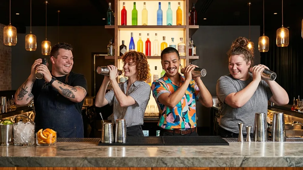 Cocktailkurs in Dortmund – Team mixt Cocktails an einer Bar unter Anleitung eines Profi-Barkeepers