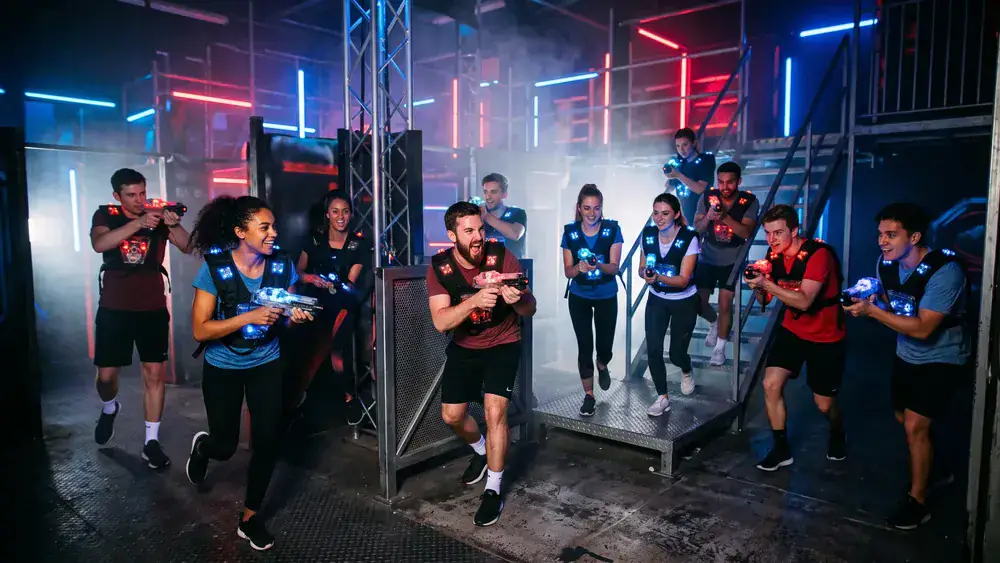 Lasertag bei Dortmund – Kollegen in Sensorwesten spielen in einer dunklen Neon-Arena