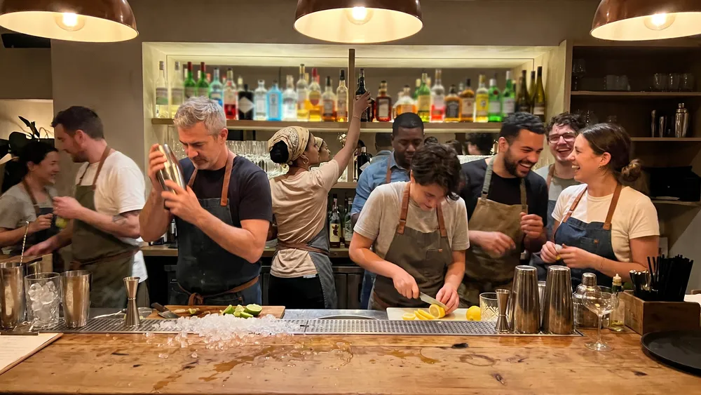 Cocktailkurs in Düsseldorf – Kollegen mixen Cocktails an einer Bar unter Anleitung