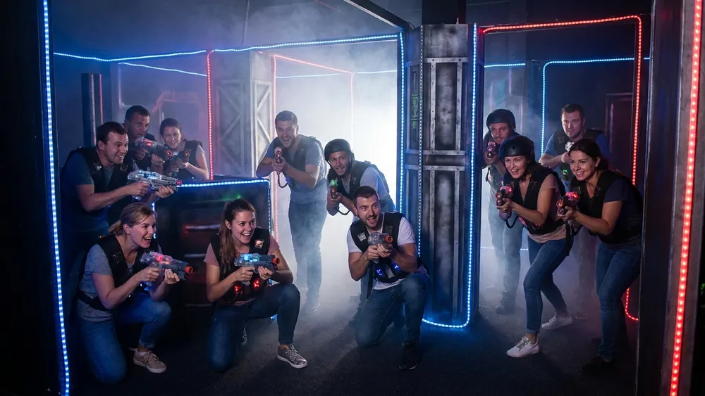 Lasertag in Düsseldorf – Gruppe mit Sensorwesten spielt in einer dunklen Neon-Arena