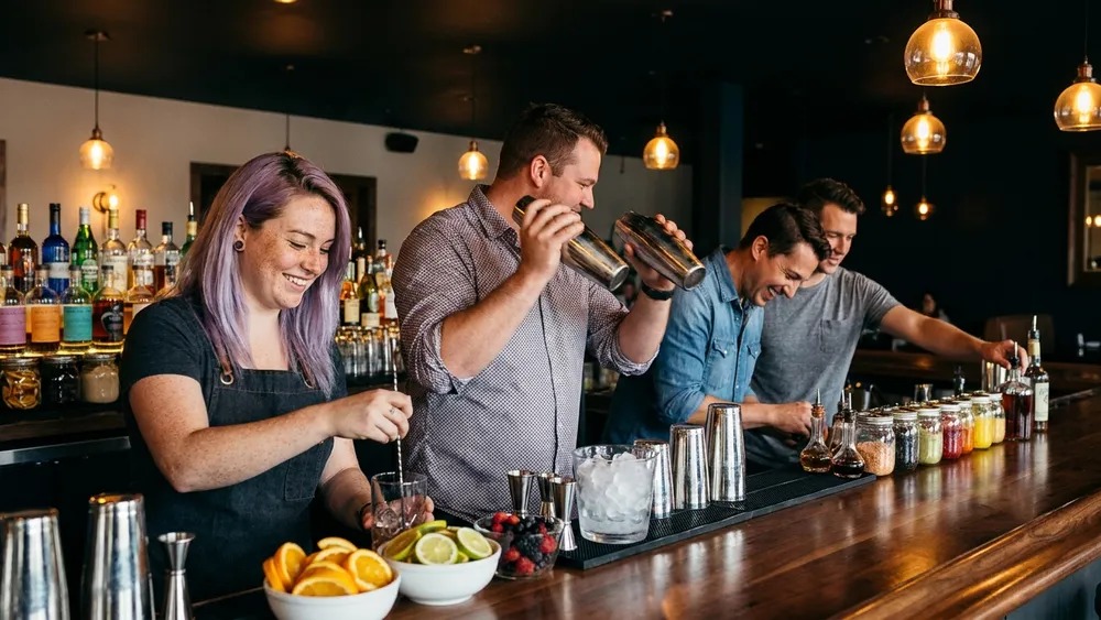 Cocktailkurs in Düsseldorf - Erwachsene mixen Cocktails an einer Bar unter Anleitung