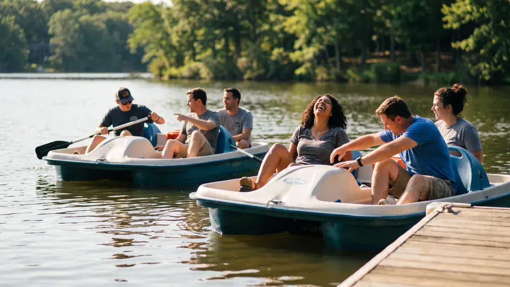 Tretbootfahren am Unterbacher See in Düsseldorf – Kollegen fahren auf mehreren Tretbooten über den See
