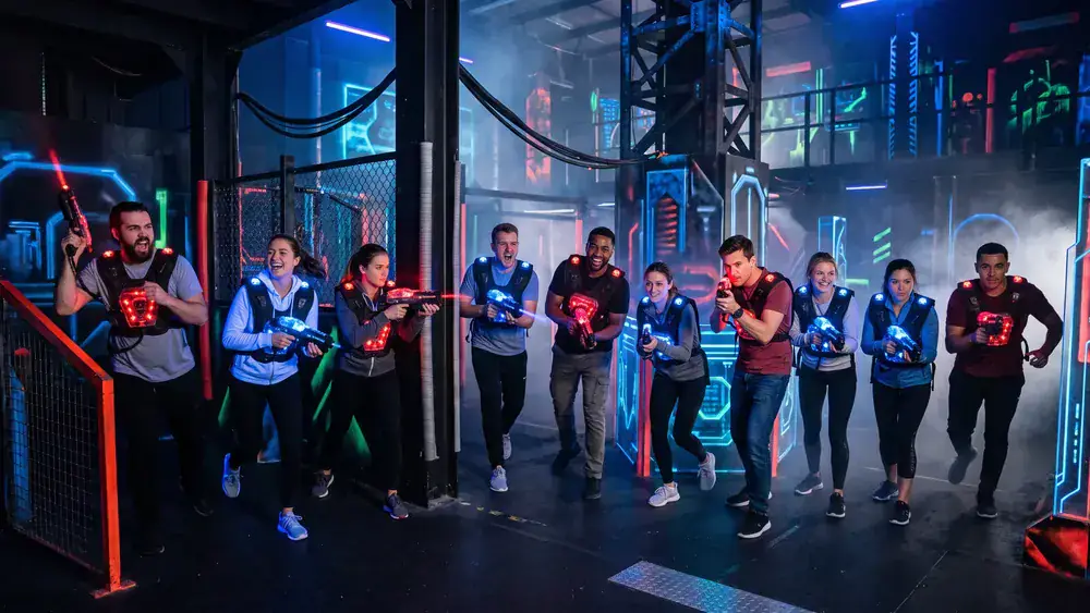 Lasertag in Düsseldorf – Kollegen in taktischen Westen spielen in einer dunklen Neon-Arena in Bilk