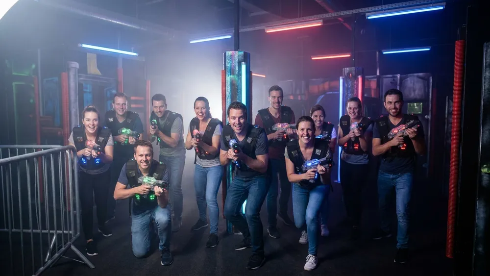 Lasertag in Hamburg – Gruppe mit Sensorwesten spielt in einer dunklen Neon-Arena im Othmarschen Park