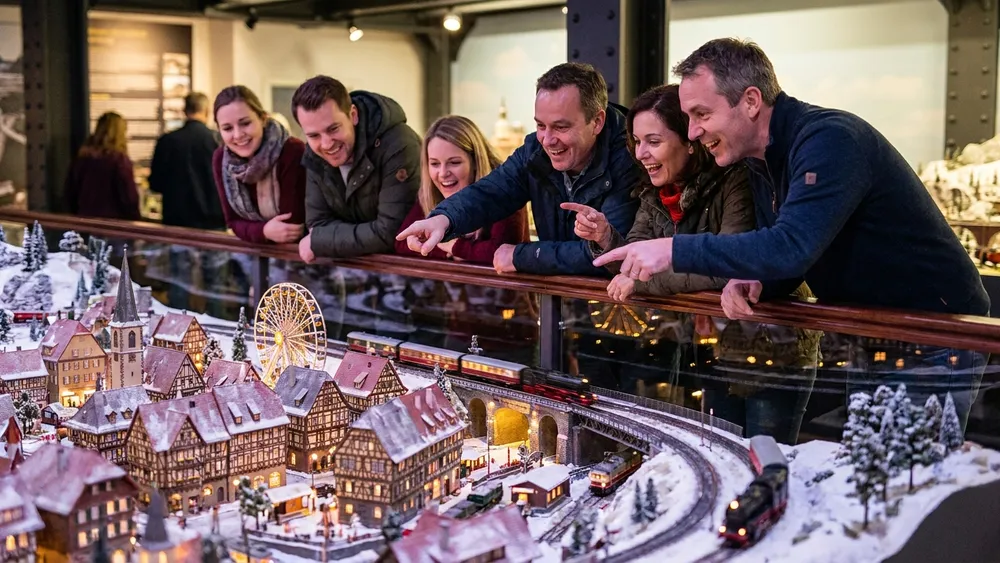 Miniatur Wunderland in Hamburg – Gruppe betrachtet ein detailliertes Modelllandschafts-Diorama mit Mini-Zügen