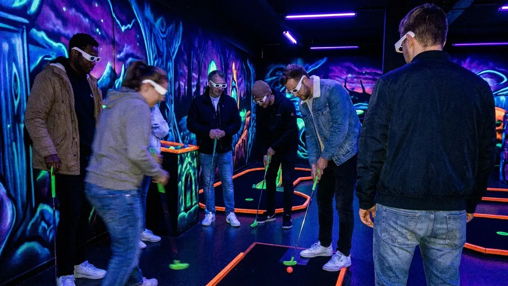 Schwarzlicht-Minigolf in Hamburg – Gruppe spielt mit 3D-Brillen unter Neonlicht in Stellingen
