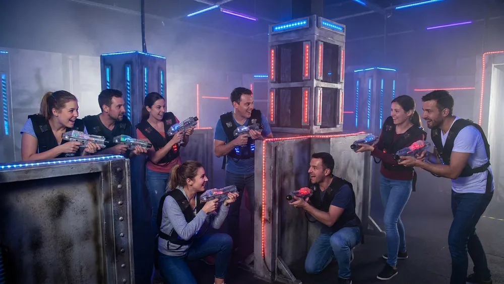 Lasertag in Hamburg - Erwachsene in tactical vests spielen in einer dunklen Neon-Arena nahe der Sportallee