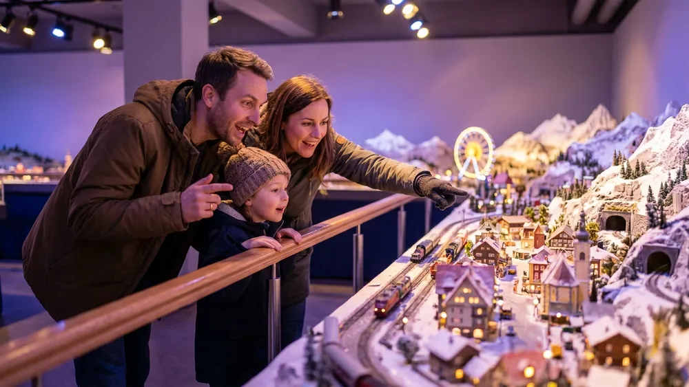 Miniatur Wunderland Hamburg – Familie betrachtet ein detailliertes Modelllandschafts-Diorama mit Mini-Zügen